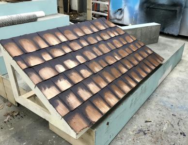 Luan and cardboard shingles painted to resemble terra cotta tile roof