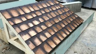 Luan and cardboard shingles painted to resemble terra cotta tile roof